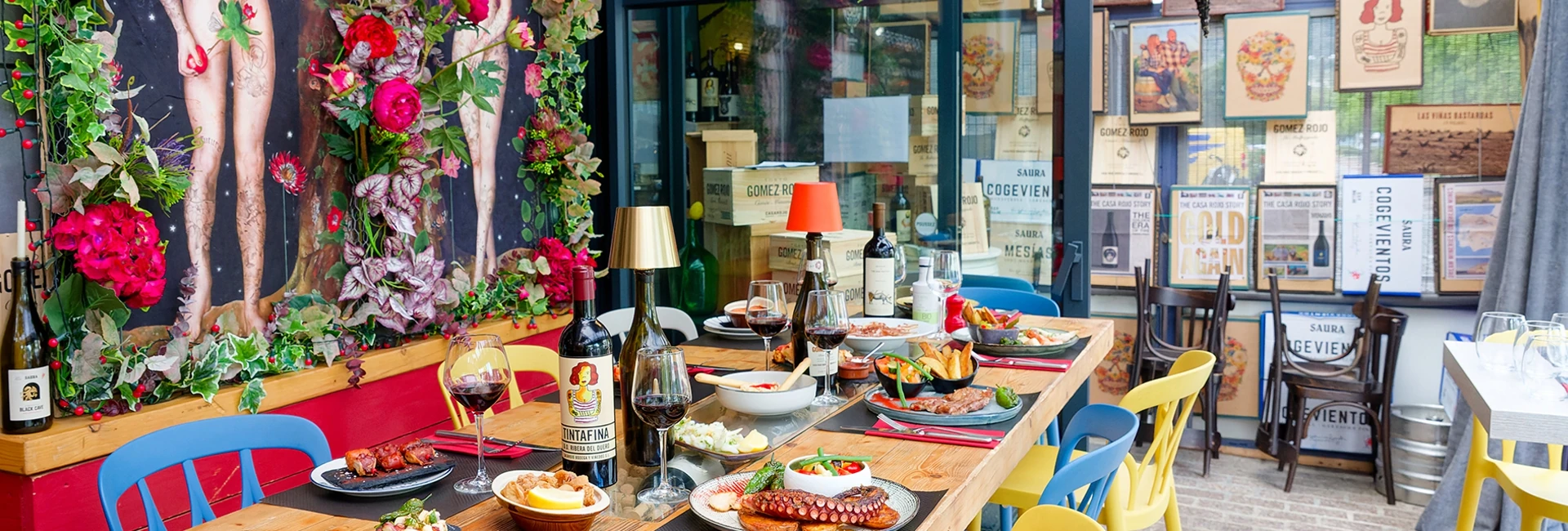 Terrasse multicolore d'un restaurant spécialisé dans la cuisine espagnole. Une table sur laquelle sont dressées d'appétissantes assiettes