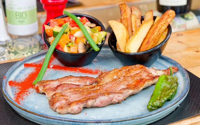 Magnifique assiette de spécialités espagnoles. Tranche de veau avec ses accompagnement petits légumes croquants et frites