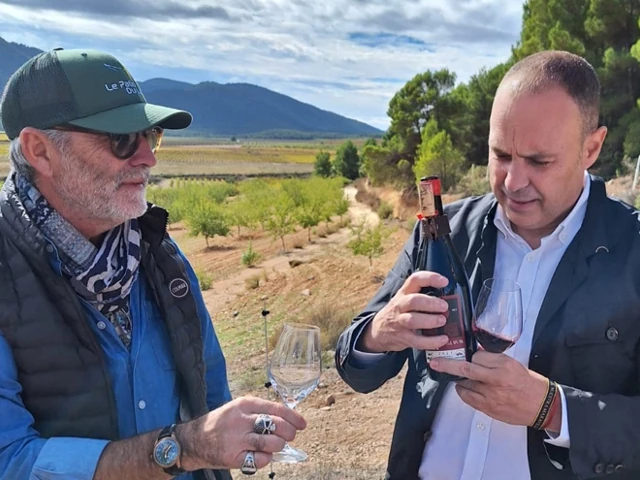 Deux hommes déguste une bouteille de vin rouge au coeur d'un vignoble