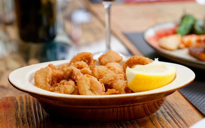 Assiette de calamars à la romaine avec un quart de citron jaune