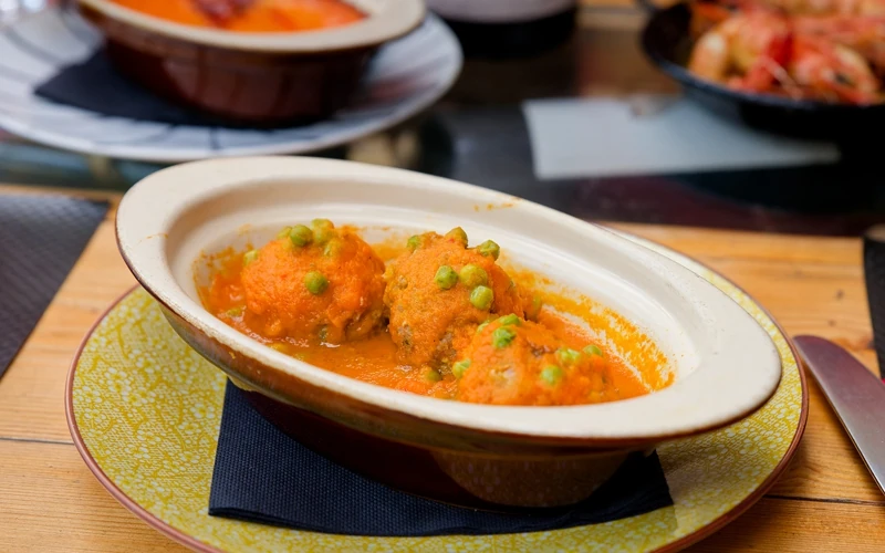 Spécialité espagnoles : assiette creuse avec des boulettes de viande et petits pois